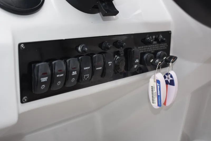 Slide: The Image of Control panel of a 2020 Regal 35 Sport Coupe boat with labeled switches and key fobs. - 32