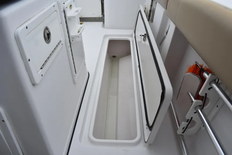 Slide: The Image of 2017 Sportsman Open 312 Center Console storage compartment with open hatch and organized equipment. - 20