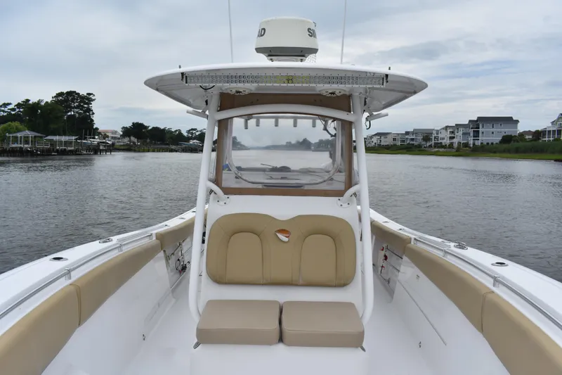 Slide: The Image of 2017 Sportsman Open 312 Center Console boat on a calm waterway, surrounded by houses. - 7