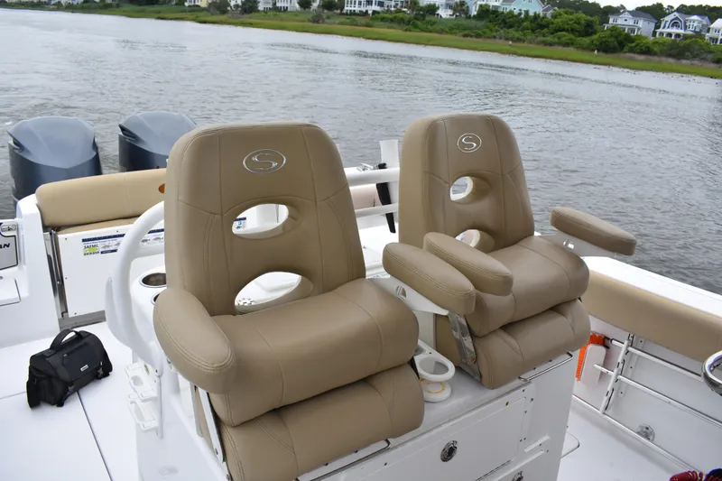 Slide: The Image of 2017 Sportsman Open 312 Center Console boat with tan leather seats on a calm river. - 17