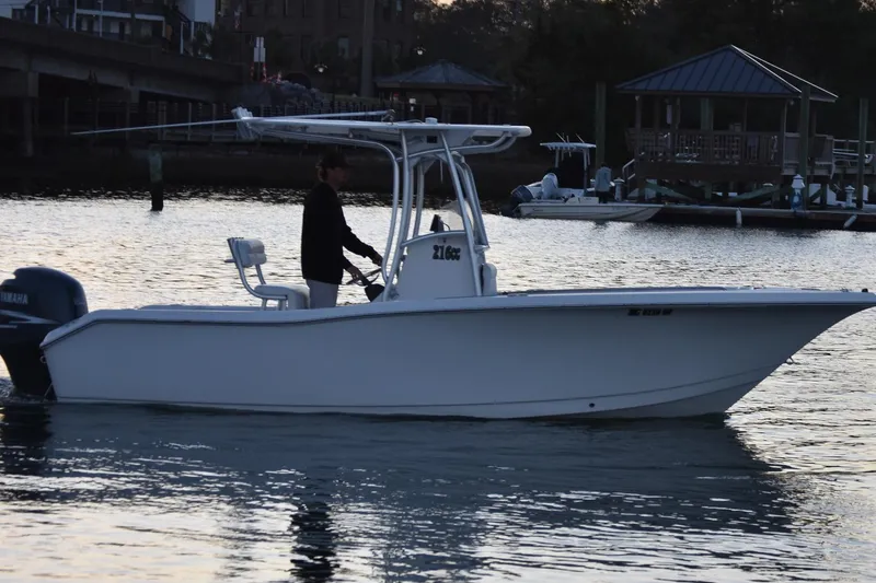 Slide: The Image of 2007 Tidewater 216 CC Adventure boat on calm water at sunset. - 2