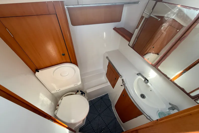Slide: The Image of Bathroom interior of 2006 Beneteau First 44.7 yacht, featuring wooden cabinetry and compact design. - 27