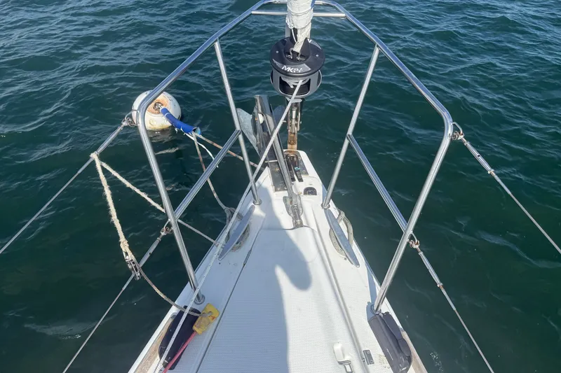 Slide: The Image of Bow view of 2006 Beneteau First 44.7 sailboat on water, showing deck and railing. - 16