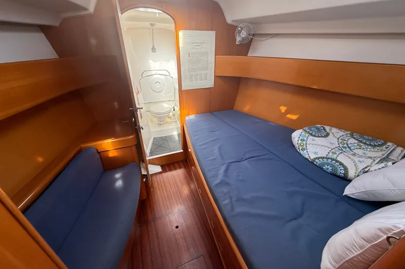 Slide: The Image of Cozy cabin interior of 2006 Beneteau First 44.7 sailboat with wooden finish and blue bedding. - 34