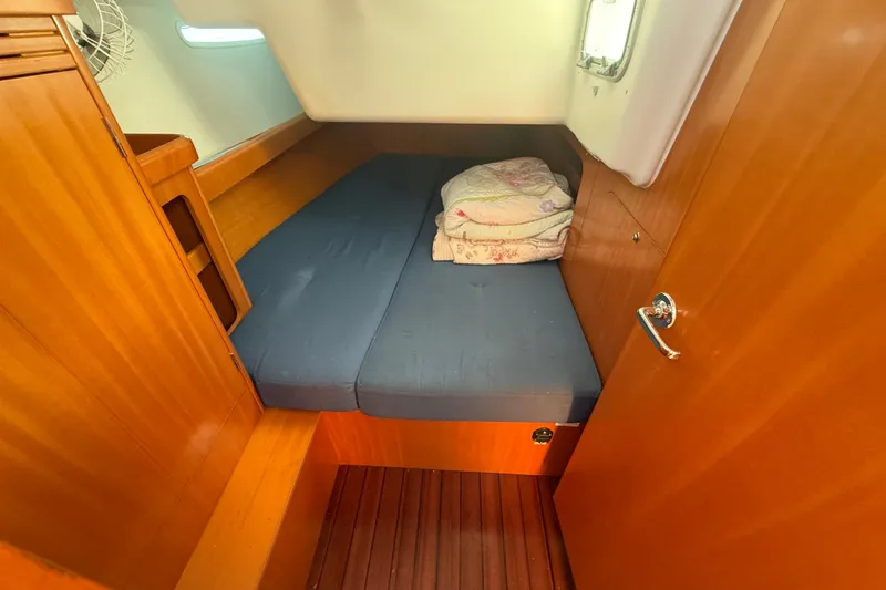 Slide: The Image of Cozy cabin interior of 2006 Beneteau First 44.7 sailboat with wooden finish and blue bedding. - 29