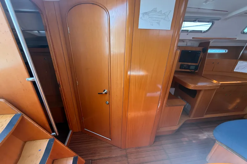 Slide: The Image of Interior of 2006 Beneteau First 44.7 sailboat with wooden cabinetry and navigation station. - 26
