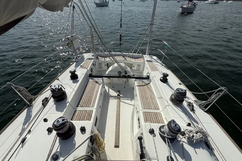 Slide: The Image of 2006 Beneteau First 44.7 sailboat deck with winches and ropes on calm water. - 7
