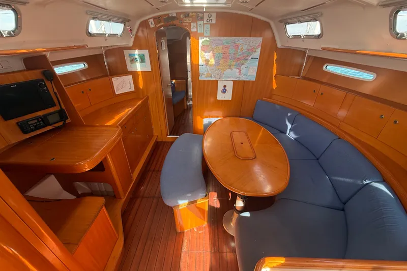 Slide: The Image of Interior of 2006 Beneteau First 44.7 sailboat with wooden furnishings and blue seating. - 22