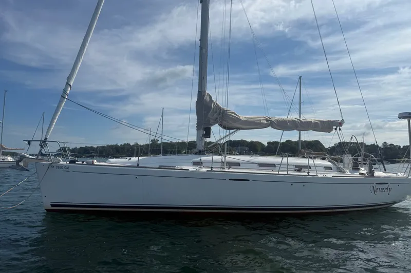 The Image of 2006 Beneteau First 44.7 sailboat on calm water under a partly cloudy sky. - 0