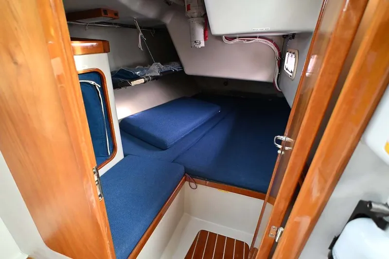 Slide: The Image of Cozy cabin interior of 1992 Santa Cruz 52 sailboat with blue cushions and wooden accents. - 21