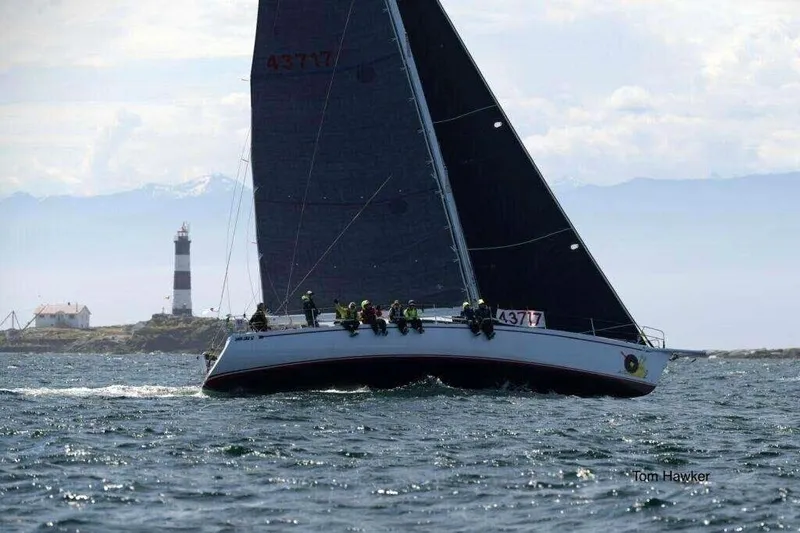Slide: The Image of Sailing yacht Santa Cruz 52 from 1992 near a lighthouse on open water. - 0