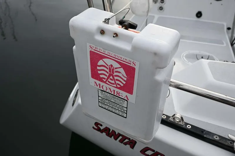 Slide: The Image of White survival equipment on a 1992 Santa Cruz 52 sailboat, docked on calm water. - 41