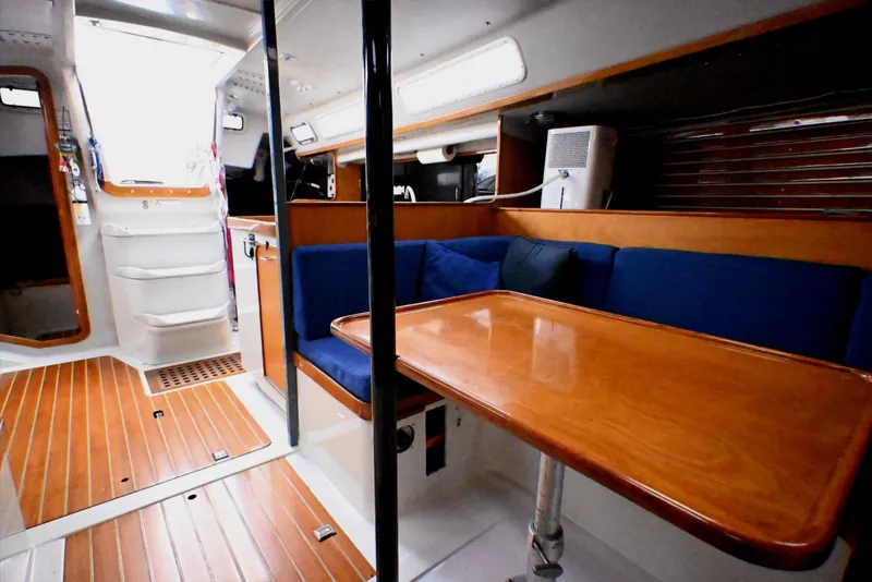 Slide: The Image of Interior of a 1992 Santa Cruz 52 yacht with wooden flooring and blue seating. - 23