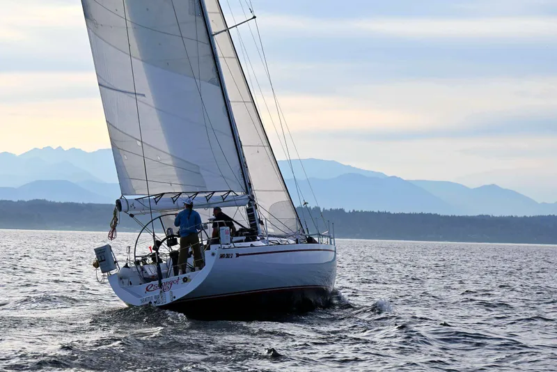 Slide: The Image of Sailing yacht Santa Cruz 52 from 1992 gliding on open water with mountainous backdrop. - 10