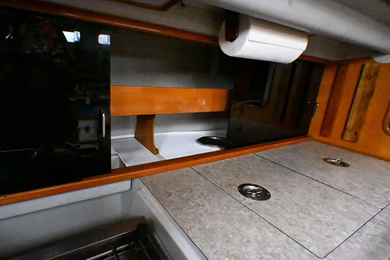 Slide: The Image of Interior of a 1992 Santa Cruz 52 yacht, featuring a compact kitchen area. - 17