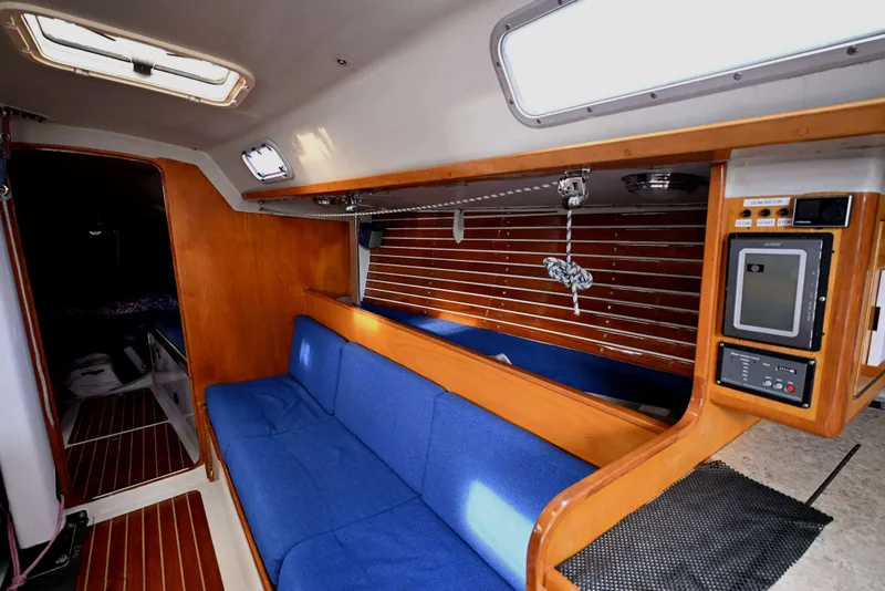 Slide: The Image of Interior of a 1992 Santa Cruz 52 sailboat with blue seating and wooden accents. - 19