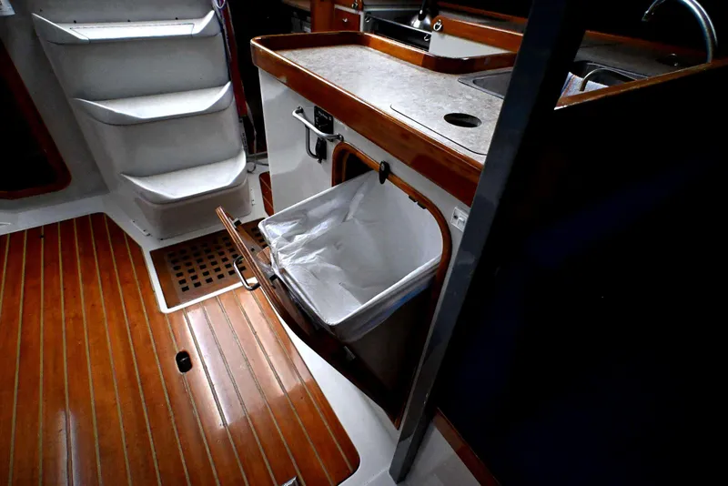 Slide: The Image of Interior of 1992 Santa Cruz 52 yacht with wooden flooring and compact kitchen area. - 16