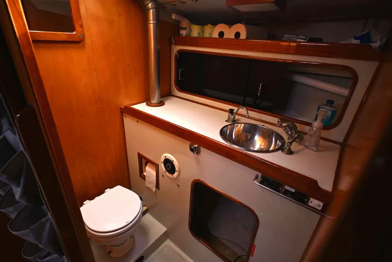 Slide: The Image of 1992 Santa Cruz 52 yacht bathroom with sink, toilet, and wooden cabinetry. - 24