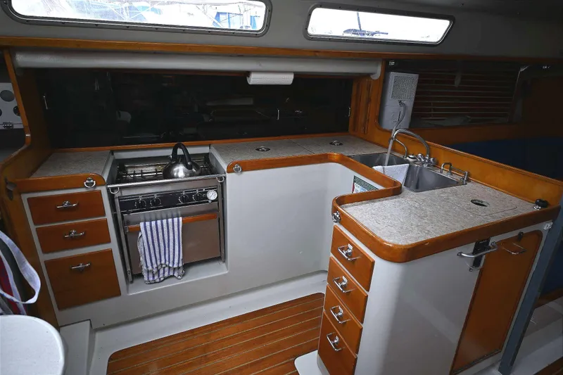 Slide: The Image of Interior of 1992 Santa Cruz 52 yacht kitchen with stove, sink, and wooden cabinetry. - 14