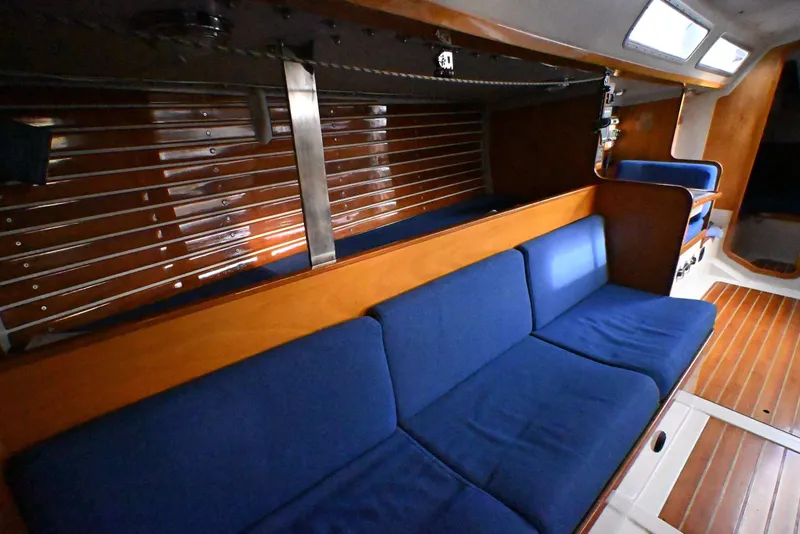 Slide: The Image of Interior of a 1992 Santa Cruz 52 yacht with blue seating and wooden accents. - 18