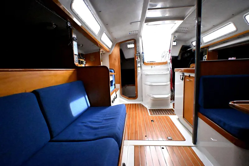 Slide: The Image of Interior of a 1992 Santa Cruz 52 sailboat with blue seating and wooden flooring. - 22