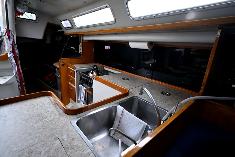 Slide: The Image of Interior of a 1992 Santa Cruz 52 yacht featuring a compact kitchen area. - 15