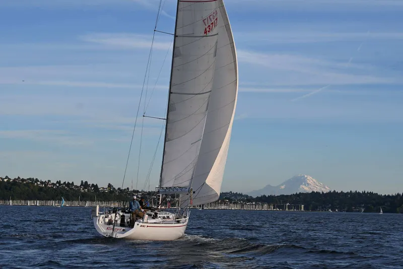 Slide: The Image of Sailboat Santa Cruz 52 (1992) gliding on water with mountain backdrop. - 12