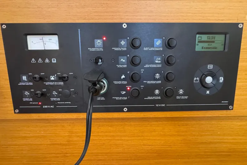 Slide: The Image of Control panel of a 2018 Jeanneau Sun Odyssey 389 sailboat, featuring various switches and gauges. - 54