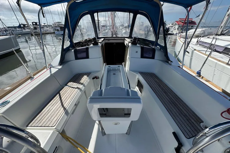 Slide: The Image of 2018 Jeanneau Sun Odyssey 389 cockpit with blue canopy and wooden seating. - 20