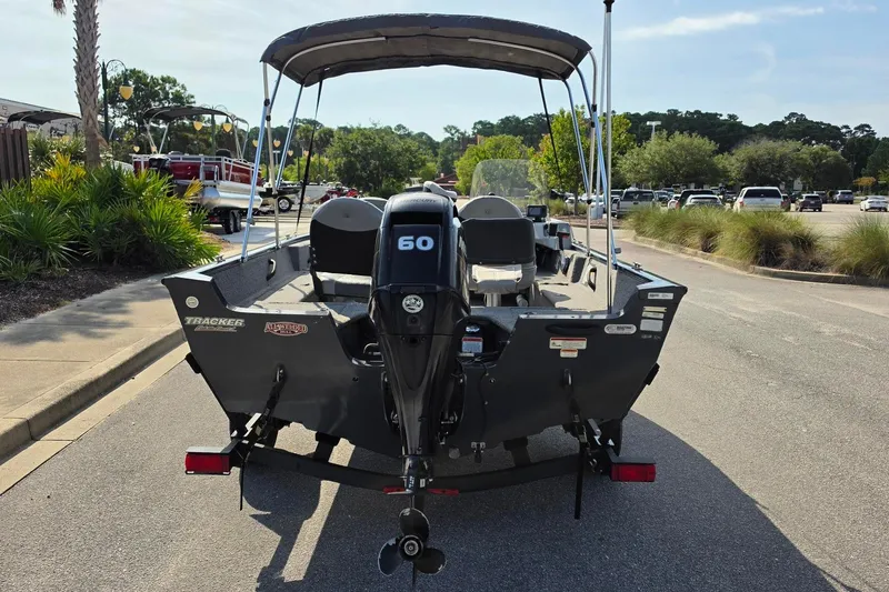 Slide: The Image of 2019 Tracker Pro Guide V-16 SC boat with 60 HP motor, parked outdoors. - 17