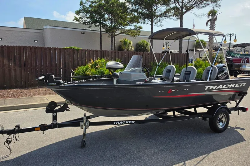 Slide: The Image of 2019 Tracker Pro Guide V-16 SC fishing boat on trailer, parked outdoors. - 19