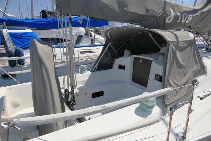 Slide: The Image of 2004 J Boats J/109 sailboat cockpit with protective cover in marina setting. - 40