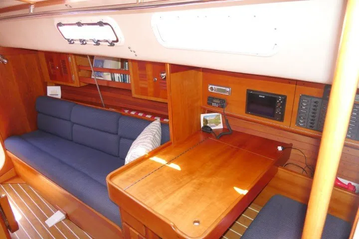 Slide: The Image of Interior of 2004 J Boats J/109 sailboat with wooden furnishings and blue seating. - 11
