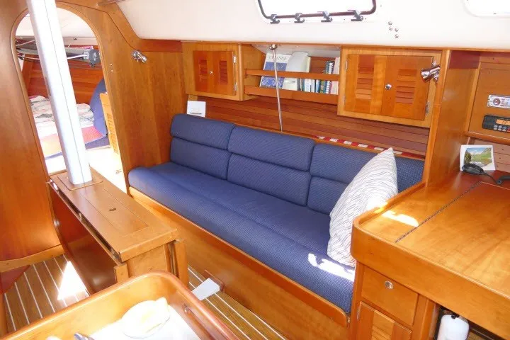 Slide: The Image of Interior of 2004 J Boats J/109 sailboat with blue sofa and wooden cabinetry. - 10