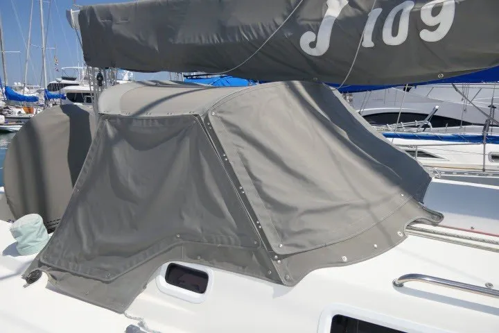 Slide: The Image of 2004 J Boats J/109 sailboat with gray canvas cover in marina setting. - 53