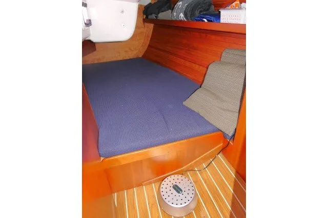 Slide: The Image of Interior cabin of 2004 J Boats J/109 with blue cushion and wooden paneling. - 32