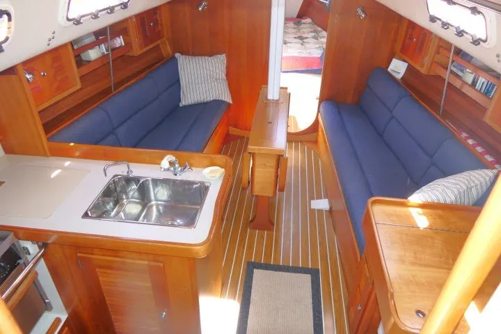 Slide: The Image of Interior of 2004 J Boats J/109 sailboat with wood finish and blue seating. - 2