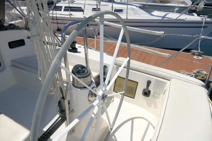 Slide: The Image of Steering wheel of a 2004 J Boats J/109 sailboat docked at a marina. - 44