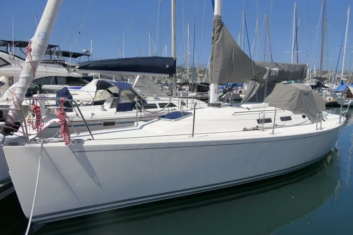 Slide: The Image of 2004 J Boats J/109 sailboat docked in a marina, surrounded by other vessels. - 73