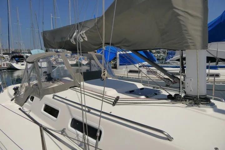 Slide: The Image of 2004 J Boats J/109 sailboat docked at marina, featuring sleek design and covered cockpit. - 54