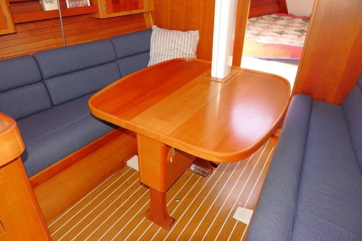 Slide: The Image of Interior of 2004 J Boats J/109 sailboat with wooden table and blue seating. - 9