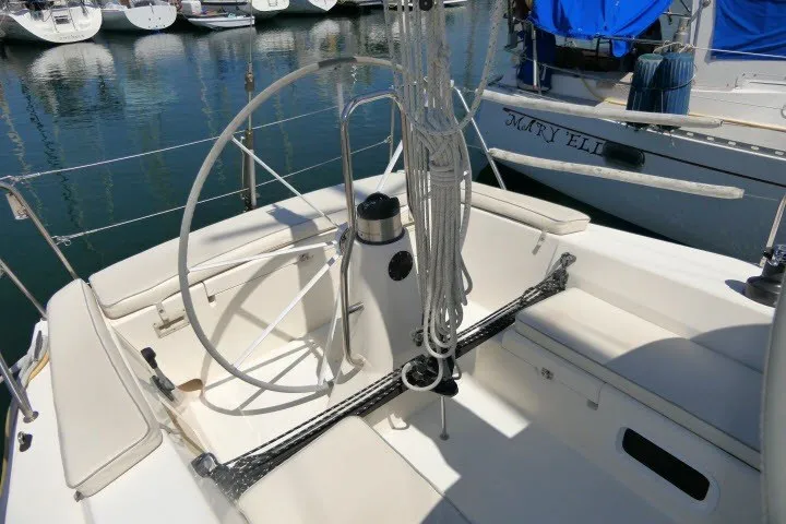 Slide: The Image of 2004 J Boats J/109 sailboat cockpit with steering wheel and rigging, docked in marina. - 48