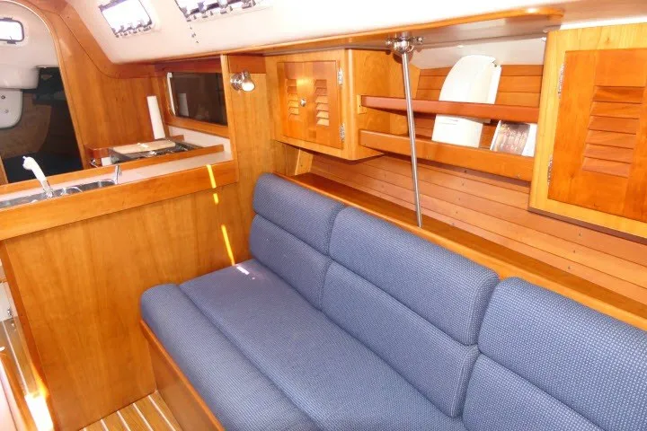 Slide: The Image of Interior of 2004 J Boats J/109 sailboat with wooden cabinetry and blue upholstered seating. - 17