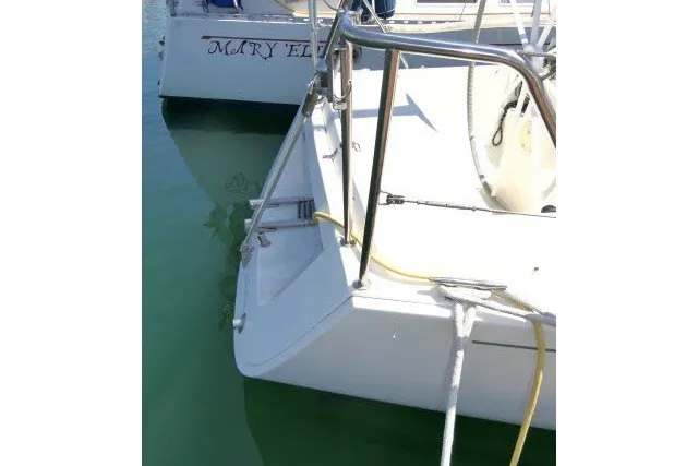 Slide: The Image of 2004 J Boats J/109 sailboat docked in marina, showing stern and railing. - 62