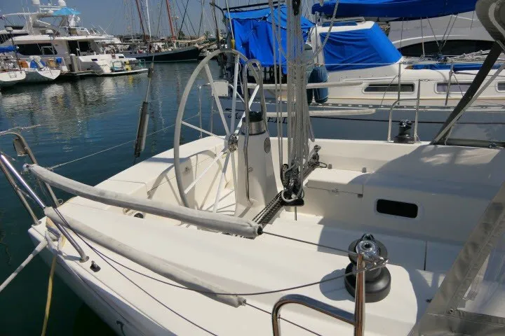 Slide: The Image of 2004 J Boats J/109 sailboat docked in marina, featuring spacious cockpit and dual steering wheels. - 46