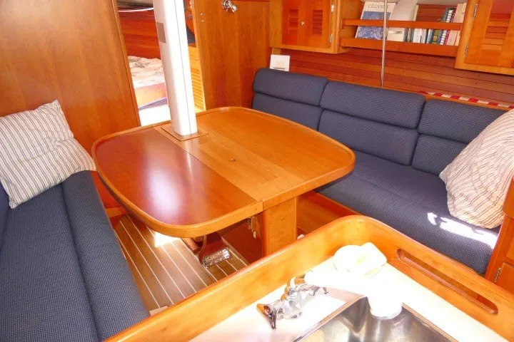 Slide: The Image of Interior of 2004 J Boats J/109 sailboat with wooden table and blue seating. - 8