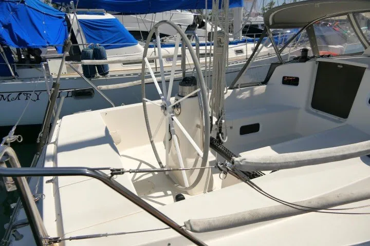 Slide: The Image of 2004 J Boats J/109 sailboat cockpit with dual steering wheels and marina backdrop. - 36