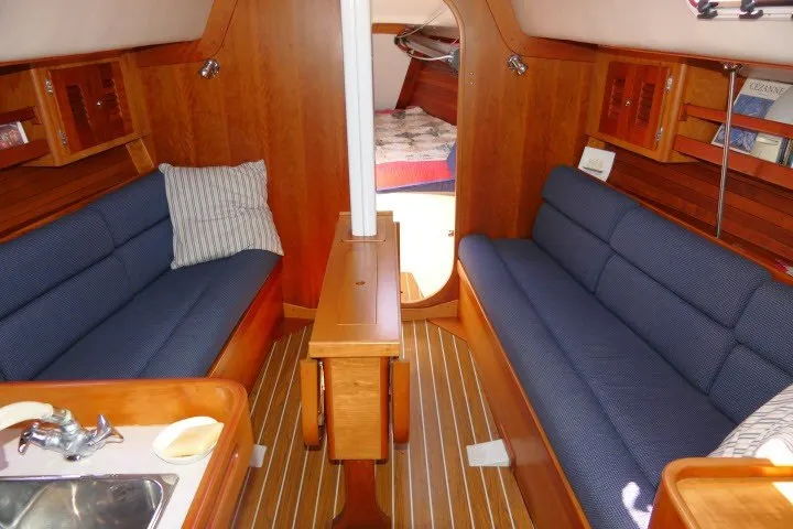 Slide: The Image of Interior of 2004 J Boats J/109 sailboat with wooden finish and blue seating. - 6