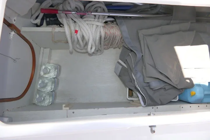 Slide: The Image of Storage compartment of a 2004 J Boats J/109 with ropes, folded sails, and water containers. - 50