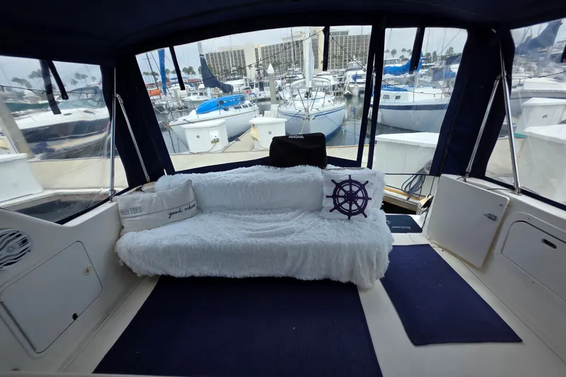 Slide: The Image of 1999 Sea Ray Sundancer 330 interior with cozy seating, nautical pillows, and marina view. - 5